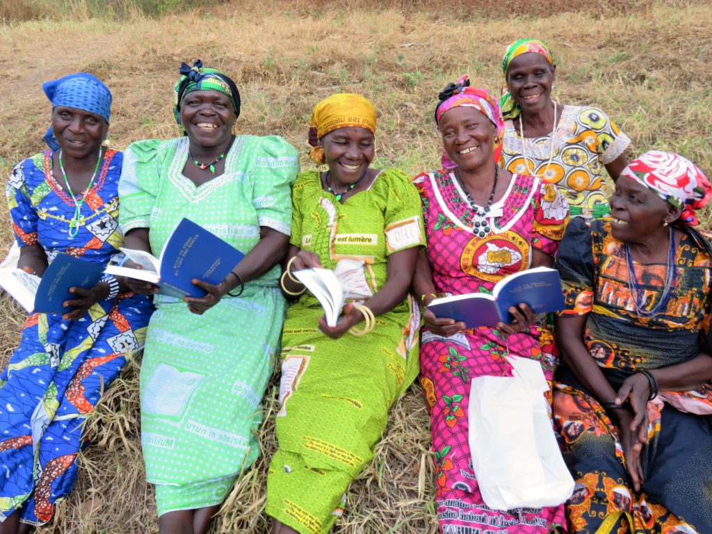 Logo women smiling and holding their new Bibles. 