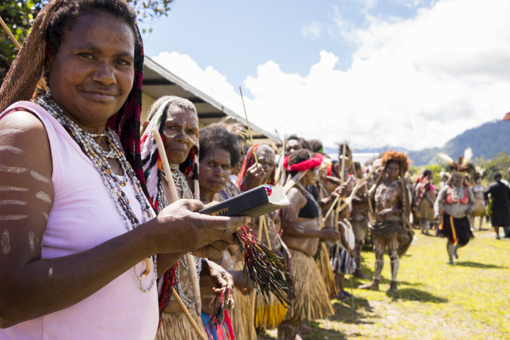 Yali women hold Bible and celebrate having the Word in their langauge. 